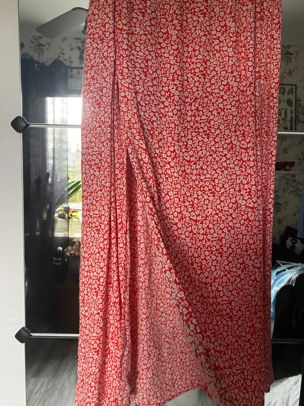 Lång röd kjol med blommor och en slits från HM. Storlek 36. 70kr plus frakt.. Kjolar.