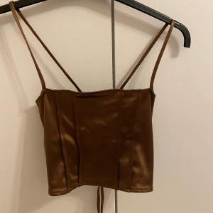 Brun silkestopp - Brun silkestopp ifrån H&M med snörning i ryggen, helt oanvänd med lapp kvar. XS men passar större då den är justerbar i ryggen🤎