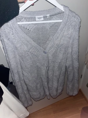Kofta med knappar - Grå stickad kofta från märket St Tropez. Stl L (liten).  Aldrig använd & i ett super fint skick.  Finns i Malmö / kan postas mor frakravgift 