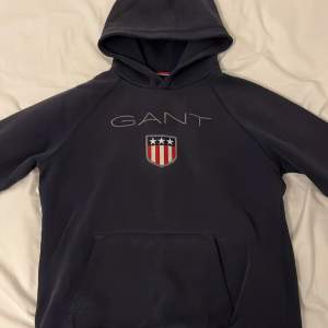 Blå Gant hoodie i extremt bra skick. Storlek 13-14år/s Ny pris 900kr    Mitt pris 250kr