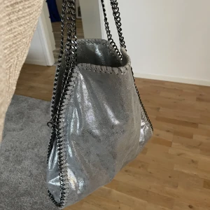 Grå väska  - Säljer min Stella McCartney liknande Väska i en grå/silvrig färg, aldrig använd.  Nypris: 700kr🫶🏽