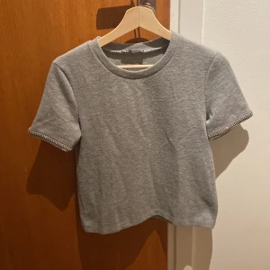 Grå kortärmad tröja med detalj på ärmarna  - Skön kortärmad grå tröja med pärlkant på ärmarna💖i bra skick