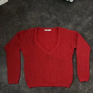 Röd stickad tröja med djup v-ringning från NA-KD. Strl. XS