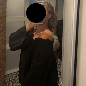 Svart långärmad blus - En svart långärmad off-shoulder topp i storlek M som är slimmad upptill och har volanger som detaljer. Säljes för 100 + frakt