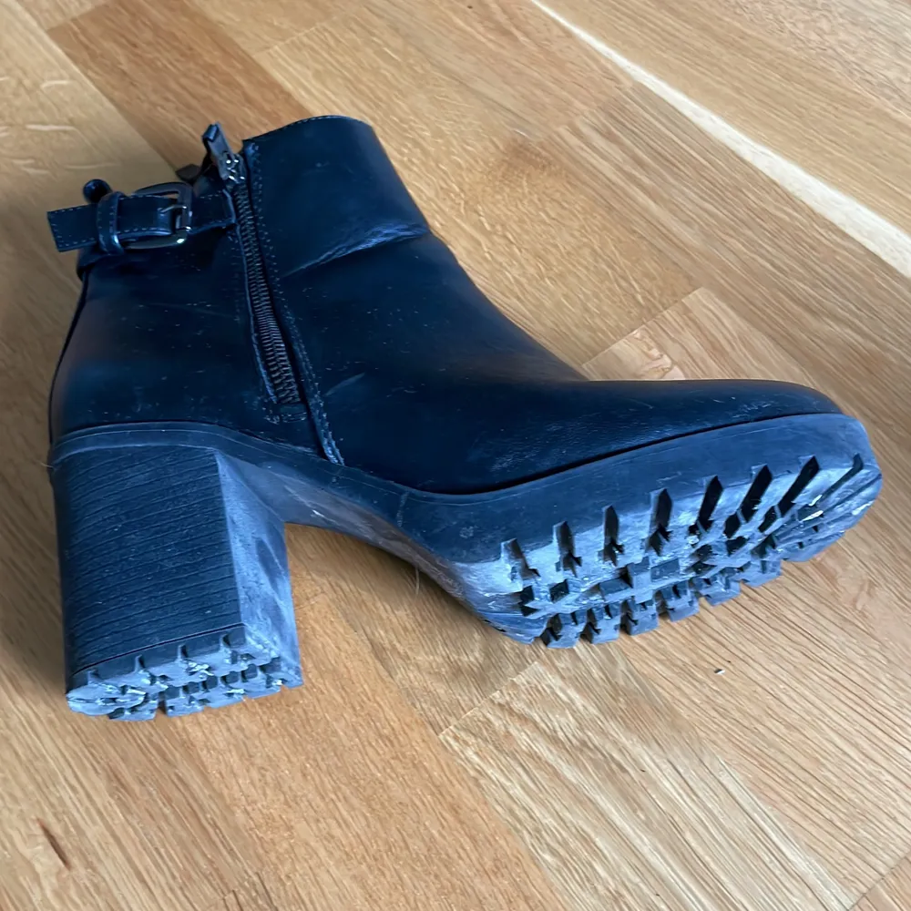 Svarta boots med klack. I skinnimitation och med fodrad insida. Använda men fortfarade i gott skick. Skor.