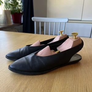 COS - Ballerina med slingback  - COS - Svarta platta ballerinaskor med slingback i resår. Perfekta dressade ballerinan! Säljes begagnat i använt skick men välskötta. Väck från användning finnes framtill, se skav baktill på bild 3. Jag skickar gärna fler bilder via dm.