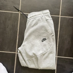 Säljer Grå Nike Tech Fleece Byxor - Säljer Grå Nike Tech Fleece Byxor. Skick 10/10 finns inga defekter och passar som de ska. De är köpta på Nike för 1200kr och de är storlek 