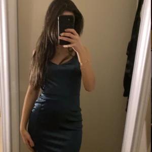 Klänning - En fin mörkgrön silke klänning. Riktigt lyxigt material. Använt ändats en gång och den är i perfekt skick. Perfekt till bal eller bröllop.