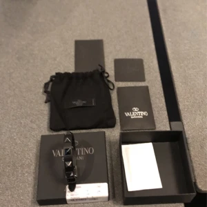 Valentino armband  - Tjena! Säljer ett sjukt trendigt valentino armband i svart. Armbandet är helt nytt och endast testat. Allt og medföljer som syns på bilden. Vid frågor och funderingar är det bara att höra av sig till mig:) Nypris: 2800kr 