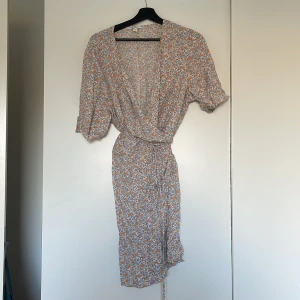 Blommig sommarklänning  - Sommrig wrapdress med knytband i midjan, använd med i bra skick