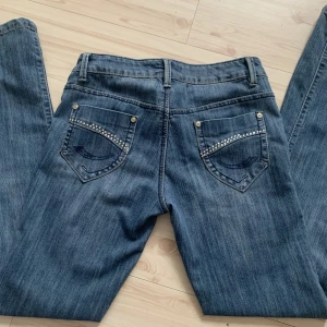 Lågmidjade jeans  - Jättefina lågmidjade jeans. De har som små silvriga stenar på båda bakfickorna, och är även lite vida i benen💞 säljer då dom inte kommer till användning hos mig 