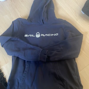 Sailracing hoodie - En marinblå sailracing hoodie som också nästan är ny. Storlek 160