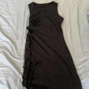 Klänning  - Fin och enkel klänning med snörning nertill. Ej använd. 