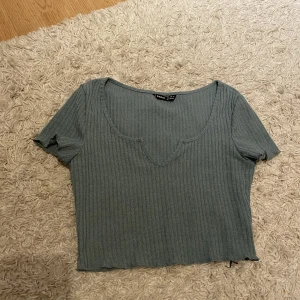 Liten topp - En fin grön/grå topp med en liten slits vid bröstet 