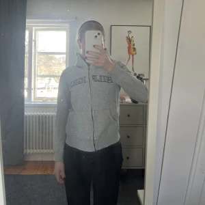 Tommy Hilfiger hoodie - Grå hoodie från Tommy Hilfiger i strl S. Lite sliten se sista bilden. Bandet till luvan medföljer!