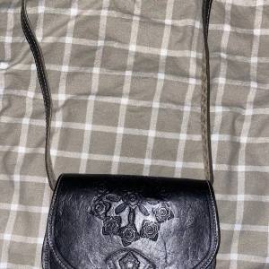 Svart axelväska  - En snygg svart 90s axelväska som går att justera längden på. 