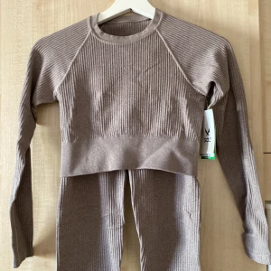 Träningsset - Träningsset med topp och tights. Toppen är oanvänd med tag kvar och tightsen är använda några gånger. Ljusbeiget, stretchigt material.