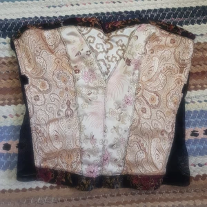 KONTAKTA INNAN KÖP NU. Korsett med vackert mönster - Säljer min korsett, använd 1 gång av mig och i fint skick, 9/10 skick?Köpt på plick. Kan knäppas på två olika rader. Passar mig som brukar ha 36/38 i toppar. Lite strechig då det är nät på sidorna.Vet inte vad frakten blir, ingår inte☀️😸