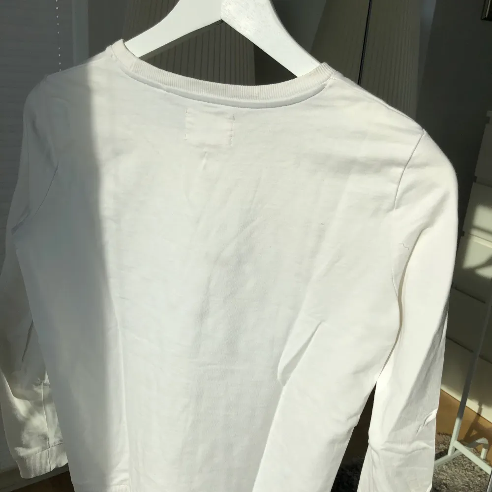 En vitt långärmad tröja med gud märke på. Den är i väldigt bra skick då den tyvärr nästan aldrig ha blivit andvänd. . Tröjor & Koftor.