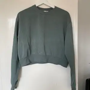 Croppad sweatshirt i en dusty grön färg
