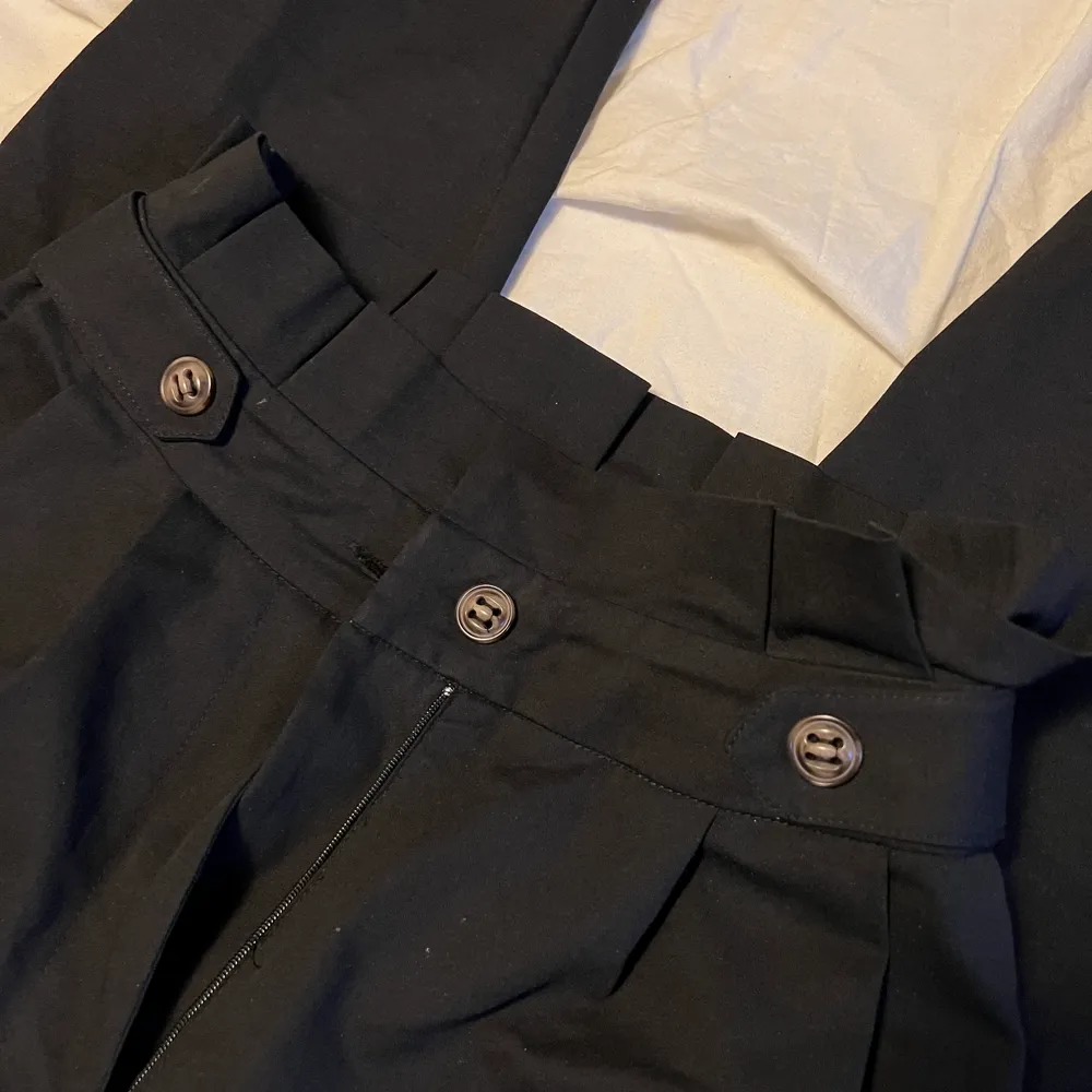 Svarta kostymbyxor från NA-KD med snygga knappar på sidor. Storlek 34. Använd enstaka gånger.. Jeans & Byxor.