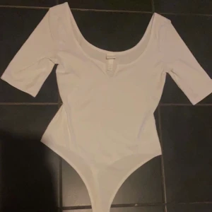 Vit ribbad stringbody  - Ett snyggt plagg som passar med det mesta! Passar både S och XS. 