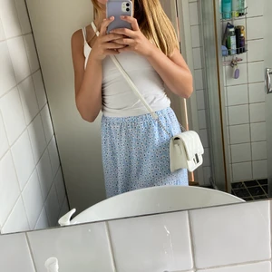 Vit crossbody bag - Liten men rymlig handväska från Glitter. Köpt för ca 1 år sedan och sparsamt använd. Köpt för 300kr och säljs för 200 men priset kan disskuteras. Köparen står för frakten.