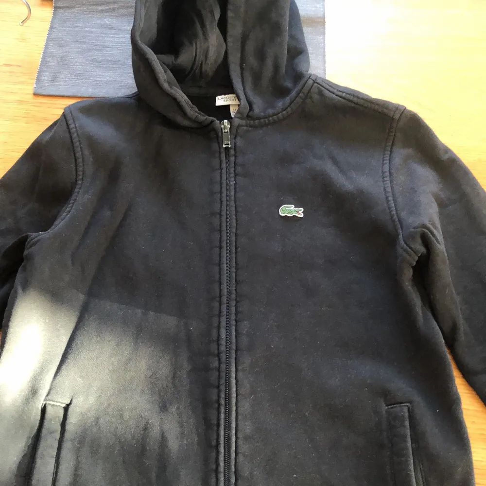En svart lacoste hoodie, passar en som är 155-161 ungefär. Hoodies.