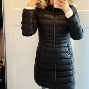 Tommy Hilfiger jacka - Lång dunkappa från Tommy Hilfiger. Sparsamt använd, inga slitningar finns.  Nypris ca 3000. Fuskpäls. 