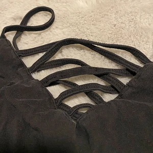 Öppen svart linne - Svart linne, öppet vid brösten.