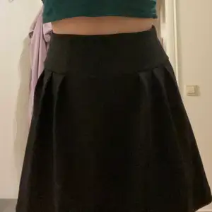En svart högmidjad kjol som jag själv köpt på second hand, den är i extremt bra skick och har fortfarande prislappen från när jag köpte den kvar. Be gärna om fler bilder om det behövs för att se tydligare hur den ser ut :))