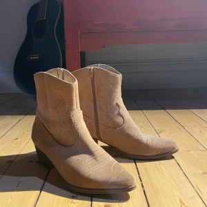 Cowboyboots - Sååå fina ljusbruna/beiga låga cowboy boots i mocka!! Köpta på humana men lite för små tyvärr :( Bra skick men använda, endast några små slitningar. Dock inget man tänker på! 60kr frakt! 