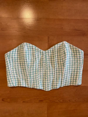 Topp Zara - Världens finaste korsettopp i bandeau modell från Zara. Tyget är stickat och påminner om houndstooth. Aldrig använd då jag köpt i fel storlek. Strl M men ej stretchig så passar S