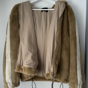 Bershka jacka - Säker en jätte mjuk och min fakepäls jacka som är mörkbeige med krämvita linjer på armar från Bershka, som jag köpte i Tyskland för några år sedan. Aldrig använd, strl M❤️