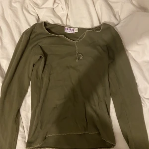 Långärmad grön tröja - jättefin långärmad tröja med lite snörning vid bröstet. det står strl 42 men tycker den passar som en S