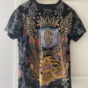 As clean Christian Audigier tisha - As drippad Christian Audigier tshirt med rhinestones, dock så har vissa av dom fallit av 🤷‍♂️ fråga för mått eller bilder!