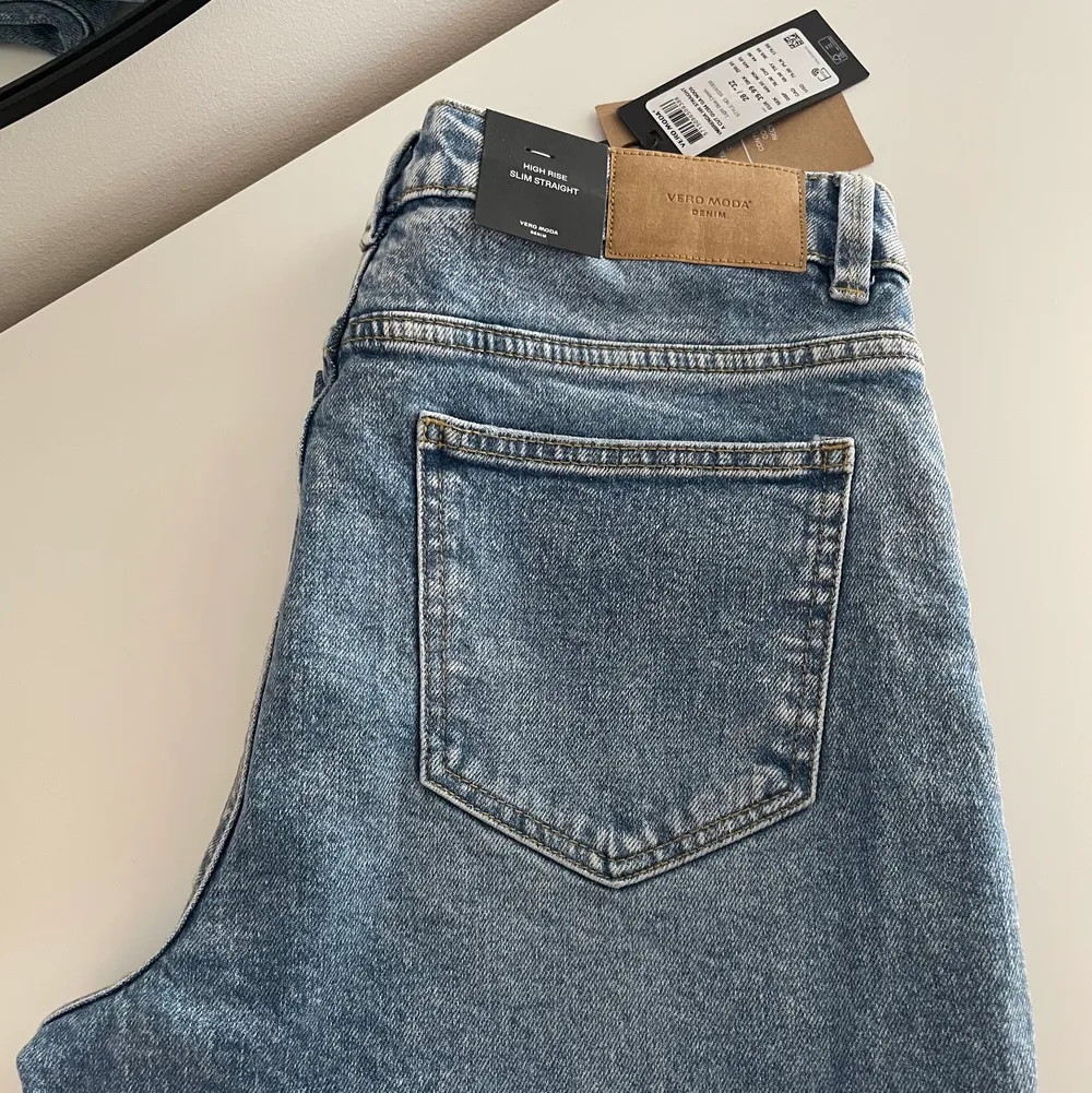 Helt nya jeans från Vero Moda, prislappen är kvar. Säljer då storleken inte passar.   Modell: VMBRENDA HR STRAIGHT A CUT GU384 GA NOOS Färg: Light Blue Denim Passform: High Rise Slim Straight Storlek: 28/”32 Nypris: 450 kr - säljer för 380 kr . Jeans & Byxor.