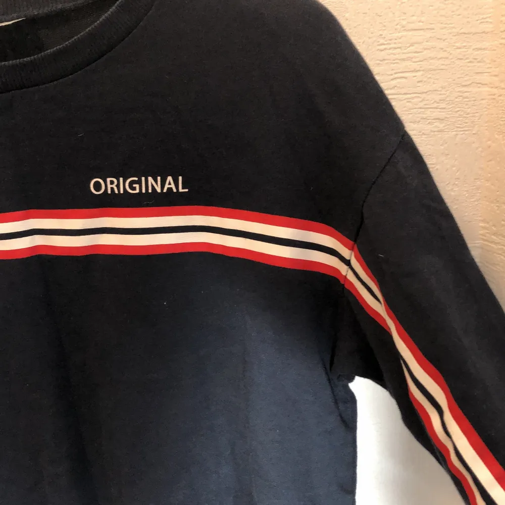 En mörkblå tröja med en text och en röd/vit rand. Andvänd ett par gånger men i bra skick. Frakt tillkommer . Tröjor & Koftor.