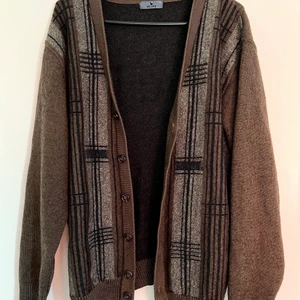 Belika Kofta - Mörkbrun kofta med långrutiga detaljer. Lös och avlång passform men sitter bra (jag har storlek 38). Koftans storlek är 52 för män. Säljer pga flytt och därmed rensning av garderoben! 