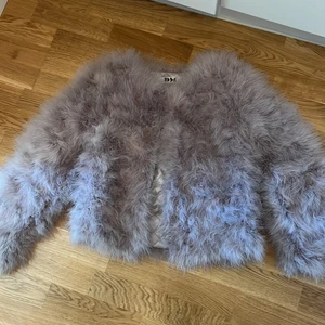Fluffig jacka med fjäderliknande materia - I helt nytt skick säljer jag min fluffig jacka. Storlek passar en Xs-S och är som ny. Färg: ljusgrå/ljuslila