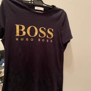 En svart hugo boss t-shirt med guld text använd ett par gånger, köpt i Emporia room 1006.