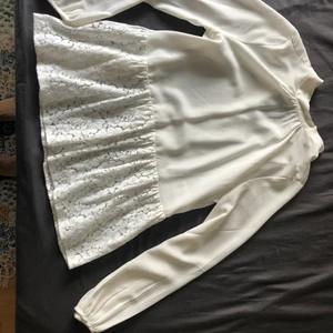 Blus - Blus med fint spets i nedre kanten.