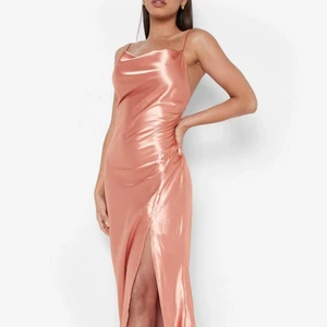 Maxiklänning stl M - Fin maxiklänning i satin med drapering och slits i färgen rosé. Aldrig använts, endast testad. Säljer den då den var för lång för mig som är 170cm, samt att den inte passade riktigt min figur. 