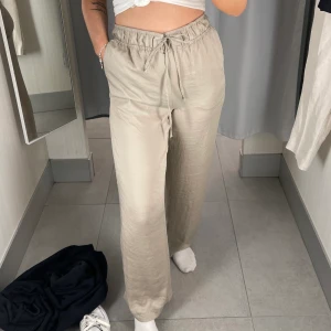 Satinbyxor - Från HM, bra skick knappt använda. Storlek M passar större och mindre då man kan knyta själv i midjan. Färgen är beige/grå