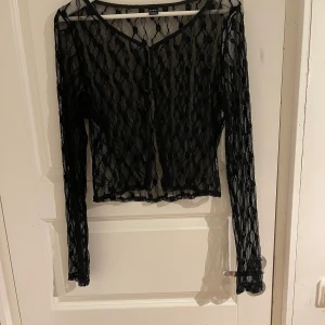 Svart ”meshtröja” med mönster - Svart meshtröja, strl L
