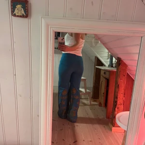 Blåa mönstrade byxor  - Blåa byxor med guldigt mönster. Köpta second hand. Jättefina men lite för stora i midjan på mig tyvärr. Så unika! Är 155 cm.