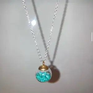 Ett halsband med en turkos/ blå julkula