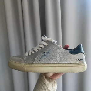 Glittriga axel arigato - Säljer mina unika silverglittriga axel arigato i ok skick. De är väl använda därav några defekter samt ett reducerat pris. Skriv om ni vill ha fler bilder!