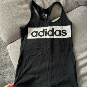 Adidas träningslinne - Adidas träningslinne - Storlek: XS - Fårg: Svart, med vitt tryck - Sparsamt använd  Säljs pga att den är förliten.