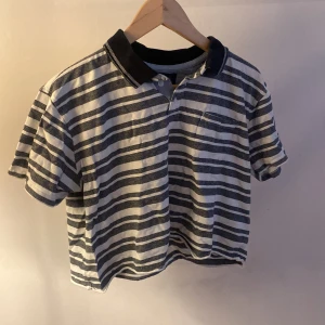 Croppad tröja  - Croppad randig tröja med krage, liten ficka på vänster bröst, okänt märke 